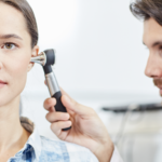 Lekarz bada kobiecie słuch w gabinecie